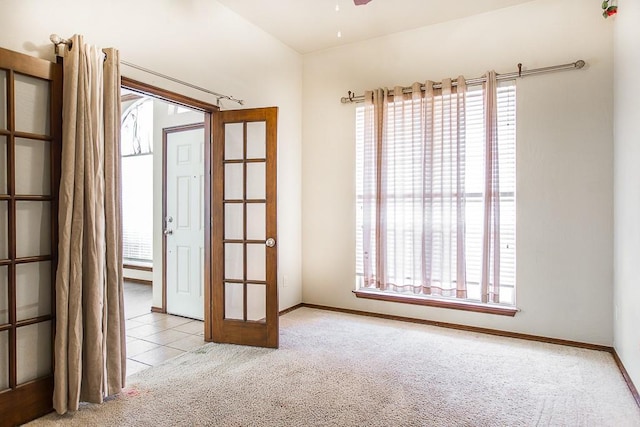 tiled spare room with ceiling fan, carpet floors, and baseboards