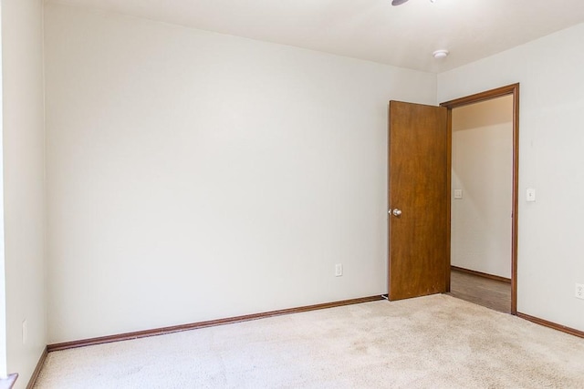 spare room featuring carpet and baseboards