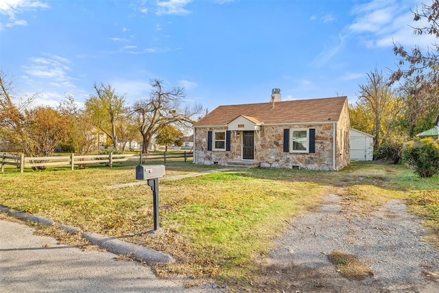 view of front of house featuring an outbuilding and a front yard