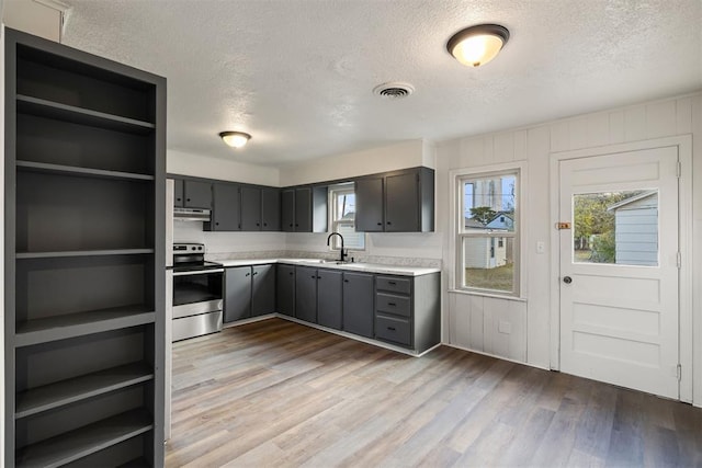 907 S Wilson Ave, El Reno, OK 73036 - kitchen with a textured ceiling, light hardwood / wood-style flooring, and stainless steel electric range oven