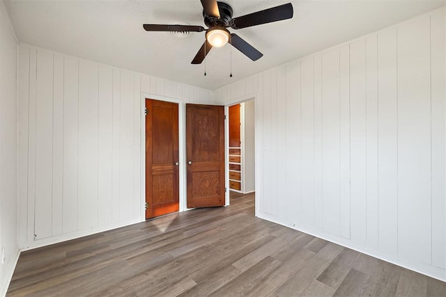 907 S Wilson Ave, El Reno, OK 73036 - spare room featuring wood-type flooring, ceiling fan, and wood walls