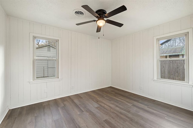 907 S Wilson Ave, El Reno, OK 73036 - spare room featuring a textured ceiling, ceiling fan, and dark wood-type flooring