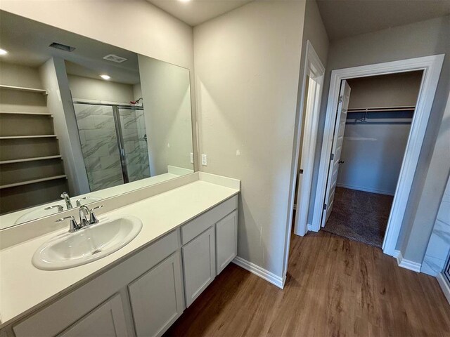 bathroom featuring hardwood / wood-style floors, vanity, and a shower with door