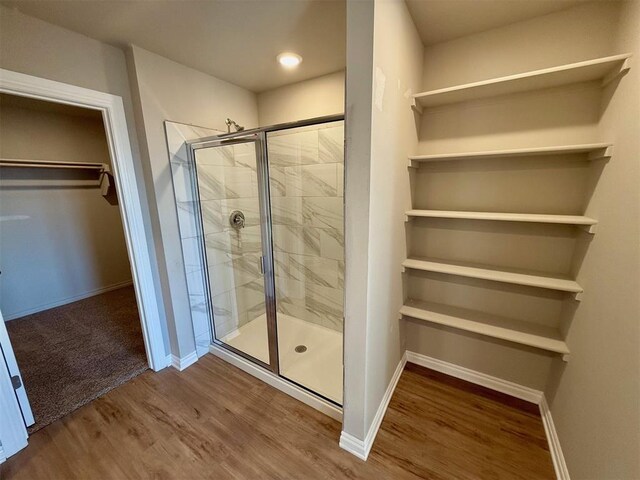 bathroom with wood-type flooring and an enclosed shower