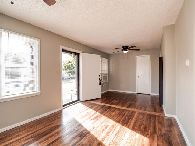 unfurnished room with ceiling fan, cooling unit, dark hardwood / wood-style flooring, and a textured ceiling