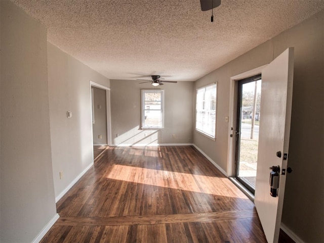 interior space featuring ceiling fan, wood-type flooring, and a textured ceiling