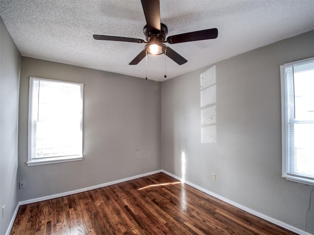 unfurnished room with a textured ceiling, plenty of natural light, and dark hardwood / wood-style floors