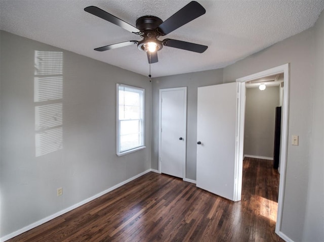 unfurnished bedroom with a textured ceiling, dark hardwood / wood-style flooring, a closet, and ceiling fan