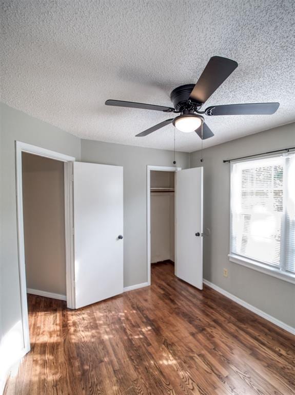 unfurnished bedroom with a closet, ceiling fan, dark hardwood / wood-style flooring, and a textured ceiling