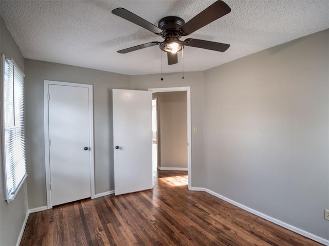 unfurnished bedroom with a textured ceiling, ceiling fan, and dark wood-type flooring