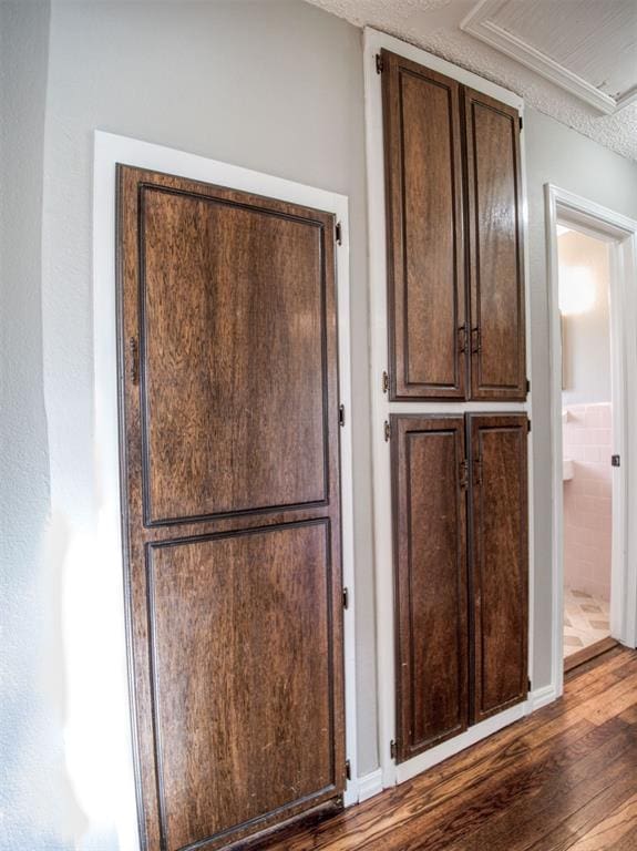 interior space featuring dark hardwood / wood-style floors, dark brown cabinets, and a textured ceiling