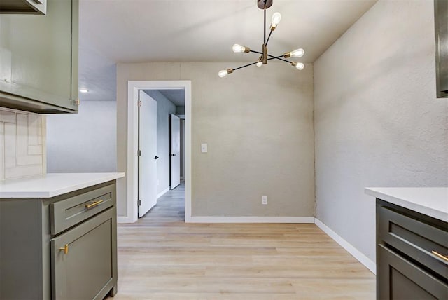 unfurnished dining area with light hardwood / wood-style floors and an inviting chandelier