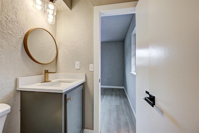 bathroom with hardwood / wood-style floors, vanity, and toilet