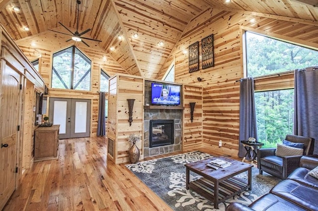 living room featuring hardwood / wood-style floors, plenty of natural light, wood ceiling, and wooden walls