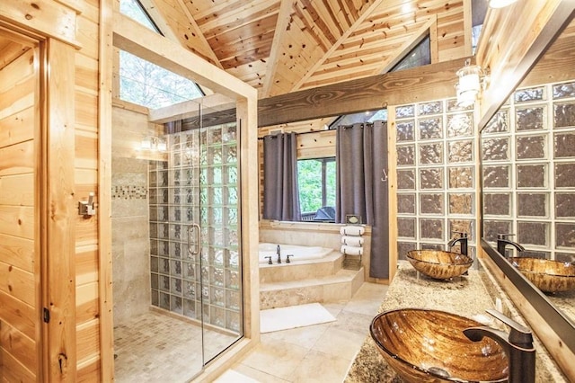 bathroom featuring vaulted ceiling with skylight, tile patterned flooring, and sink