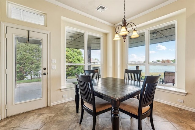 tiled dining area featuring plenty of natural light, a water view, an inviting chandelier, and ornamental molding