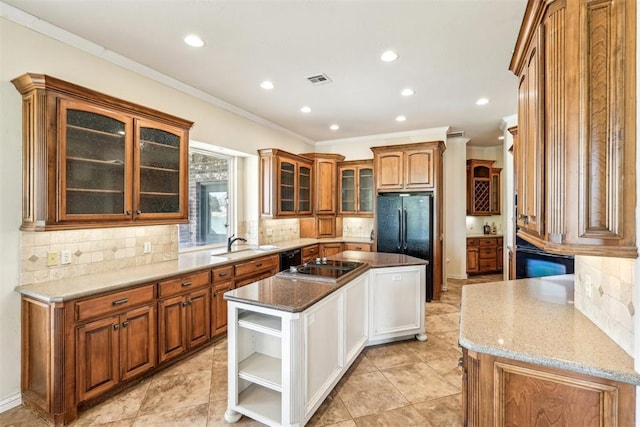 kitchen with backsplash, crown molding, a center island, and light stone counters