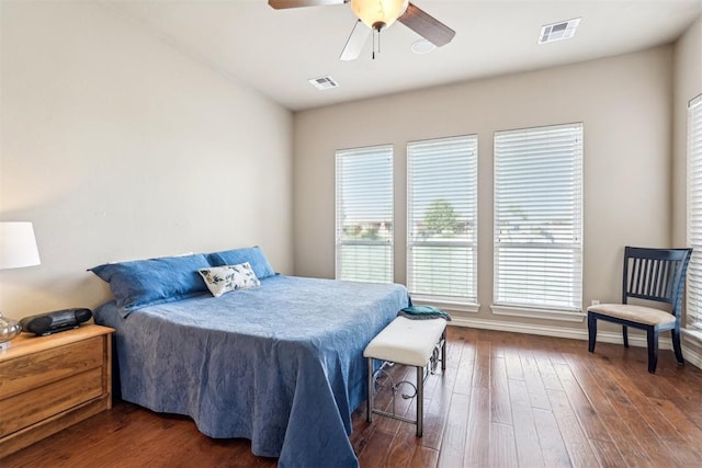 bedroom featuring dark hardwood / wood-style flooring, multiple windows, and ceiling fan