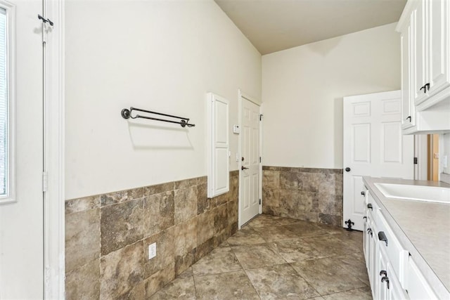 bathroom with vanity and tile walls