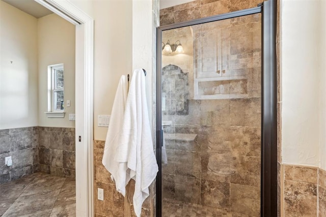 bathroom with a shower with shower door and tile walls