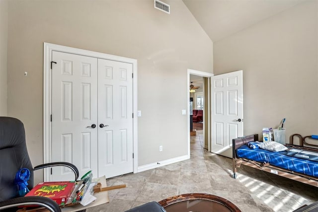 bedroom featuring high vaulted ceiling and a closet