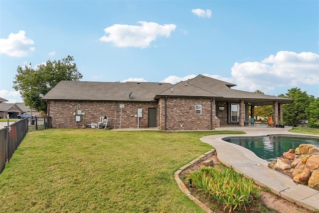 back of house featuring a fenced in pool, a patio area, and a lawn