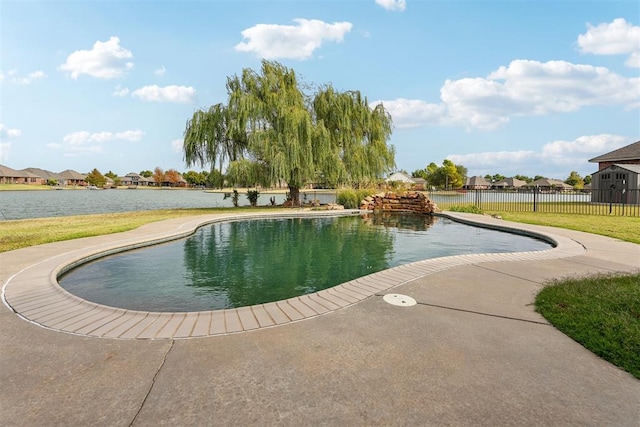 view of swimming pool featuring a lawn and a water view