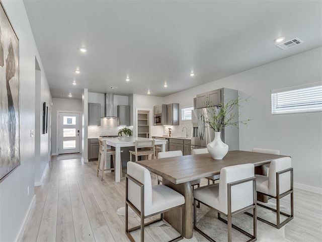 dining space featuring sink and light wood-type flooring