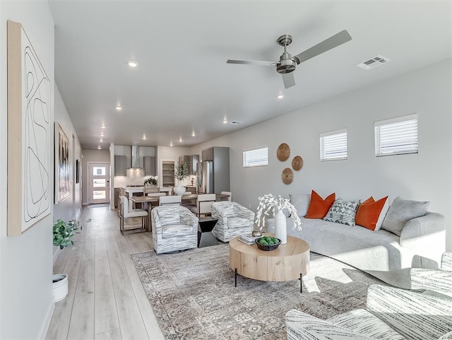 living room featuring ceiling fan and light hardwood / wood-style floors