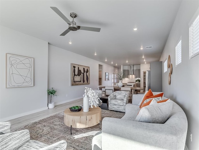 living room featuring ceiling fan and light hardwood / wood-style flooring