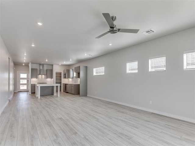 unfurnished living room featuring ceiling fan and light wood-type flooring