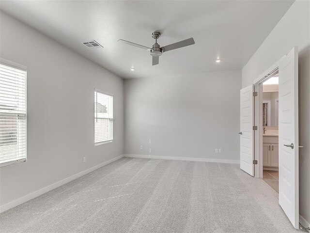 carpeted spare room featuring ceiling fan