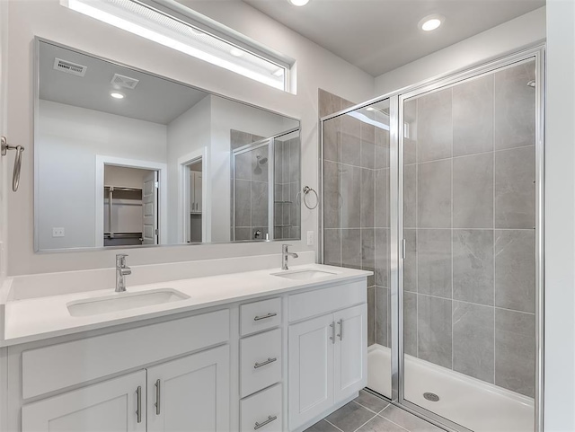 bathroom with tile patterned flooring, vanity, and walk in shower