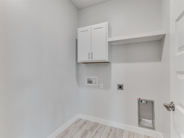 clothes washing area with cabinets, hookup for a washing machine, light hardwood / wood-style flooring, and electric dryer hookup