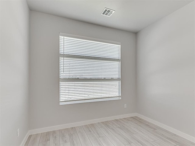 empty room featuring light wood-type flooring and plenty of natural light