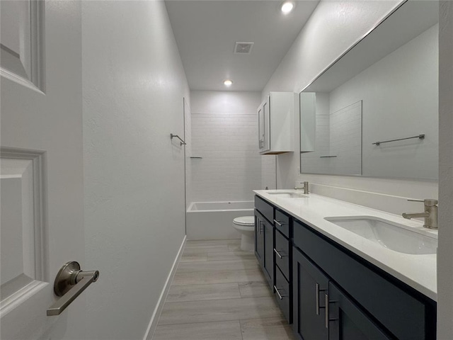 full bathroom featuring toilet, tiled shower / bath, and vanity