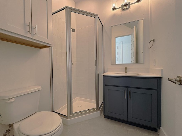 bathroom featuring toilet, tile patterned flooring, walk in shower, and vanity