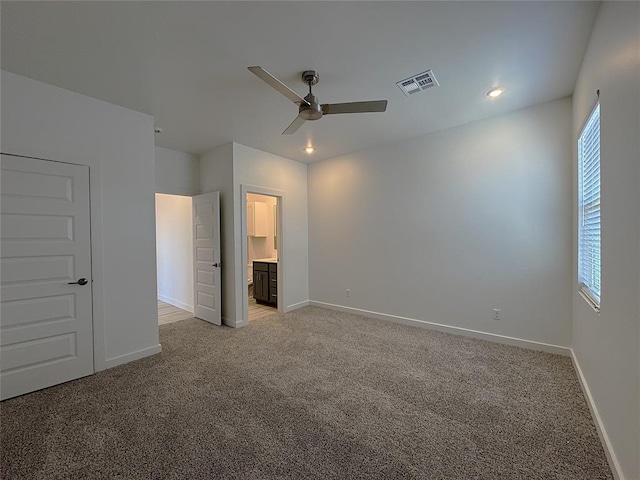 unfurnished bedroom with ceiling fan, connected bathroom, and light carpet