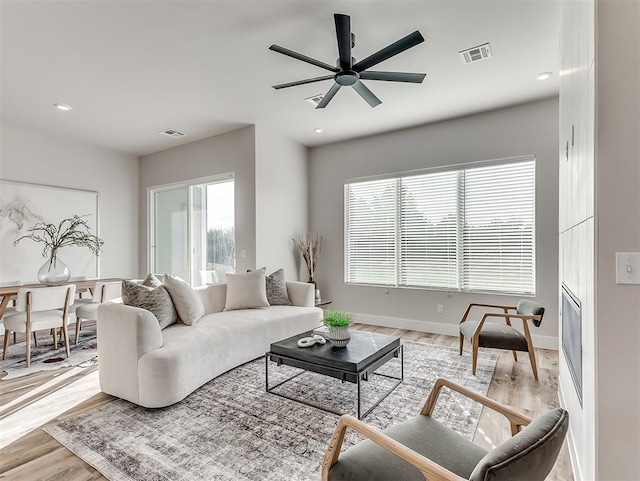 living room featuring light wood-type flooring and ceiling fan