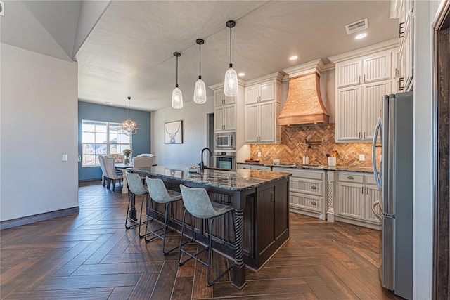 2063 County Road 1336, Blanchard, OK 73010 - kitchen with dark stone counters, tasteful backsplash, recessed lighting, a kitchen bar, and an island with sink
