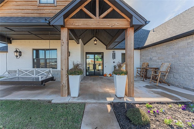 2063 County Road 1336, Blanchard, OK 73010 - view of exterior entry with a patio area, roof with shingles, and brick siding