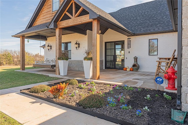 2063 County Road 1336, Blanchard, OK 73010 - entrance to property featuring a shingled roof, brick siding, and covered porch