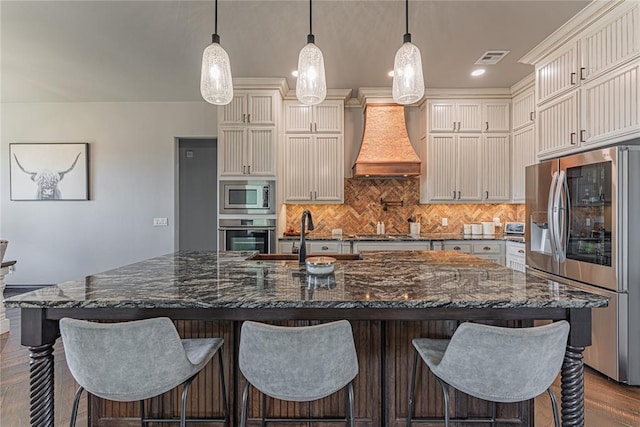 2063 County Road 1336, Blanchard, OK 73010 - kitchen featuring appliances with stainless steel finishes, backsplash, dark wood-style floors, premium range hood, and a kitchen breakfast bar