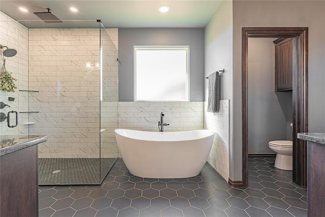 2063 County Road 1336, Blanchard, OK 73010 - full bathroom with a shower stall, a soaking tub, tile patterned flooring, recessed lighting, and tile walls