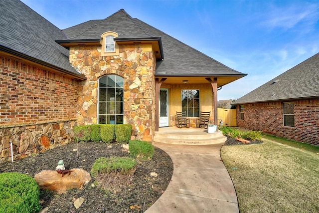 entrance to property featuring a lawn and a patio