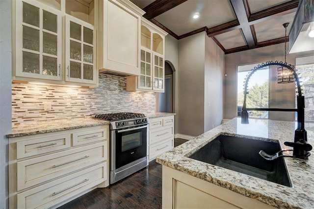 kitchen with beam ceiling, stainless steel gas range oven, sink, coffered ceiling, and light stone countertops