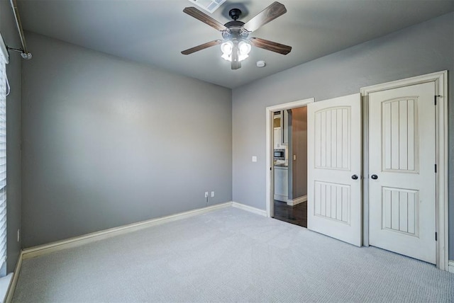 unfurnished bedroom with ceiling fan, a closet, and carpet floors