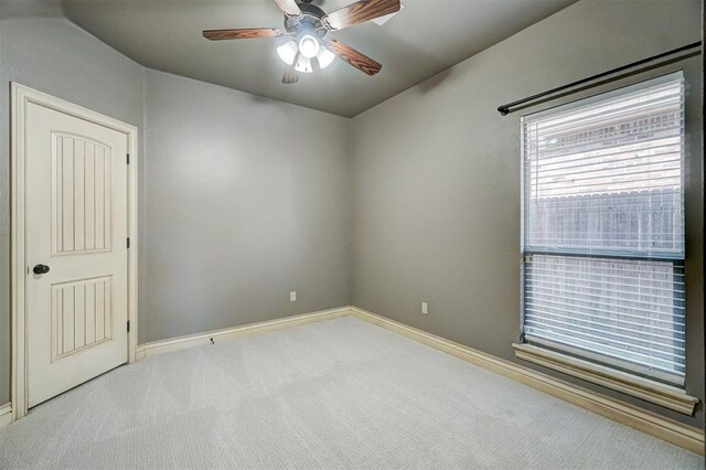 carpeted spare room featuring ceiling fan