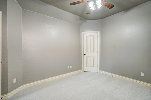 spare room featuring ceiling fan, light colored carpet, and lofted ceiling