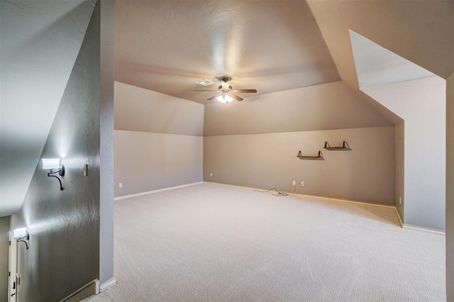 additional living space featuring ceiling fan, light colored carpet, and vaulted ceiling